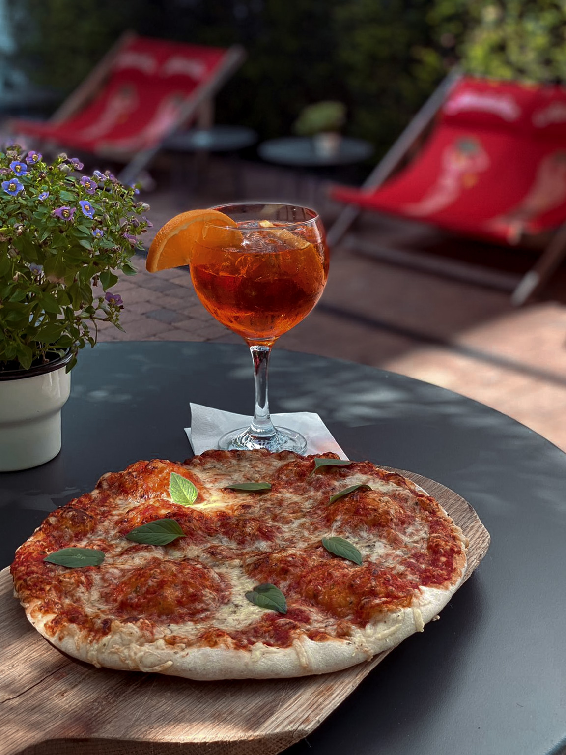 Detailansicht einer Pizza und einem Glas Aperol